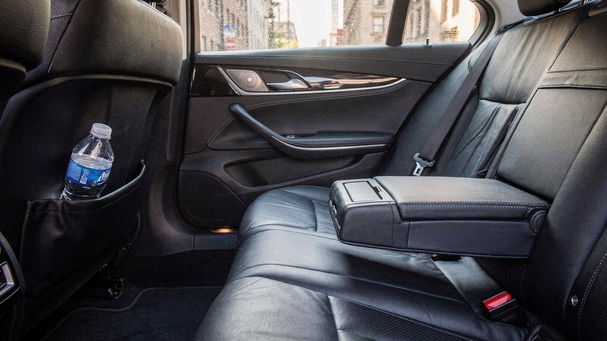Rear cabin of an executive sedan showing extended legroom and a folded bottle of water in the door pocket